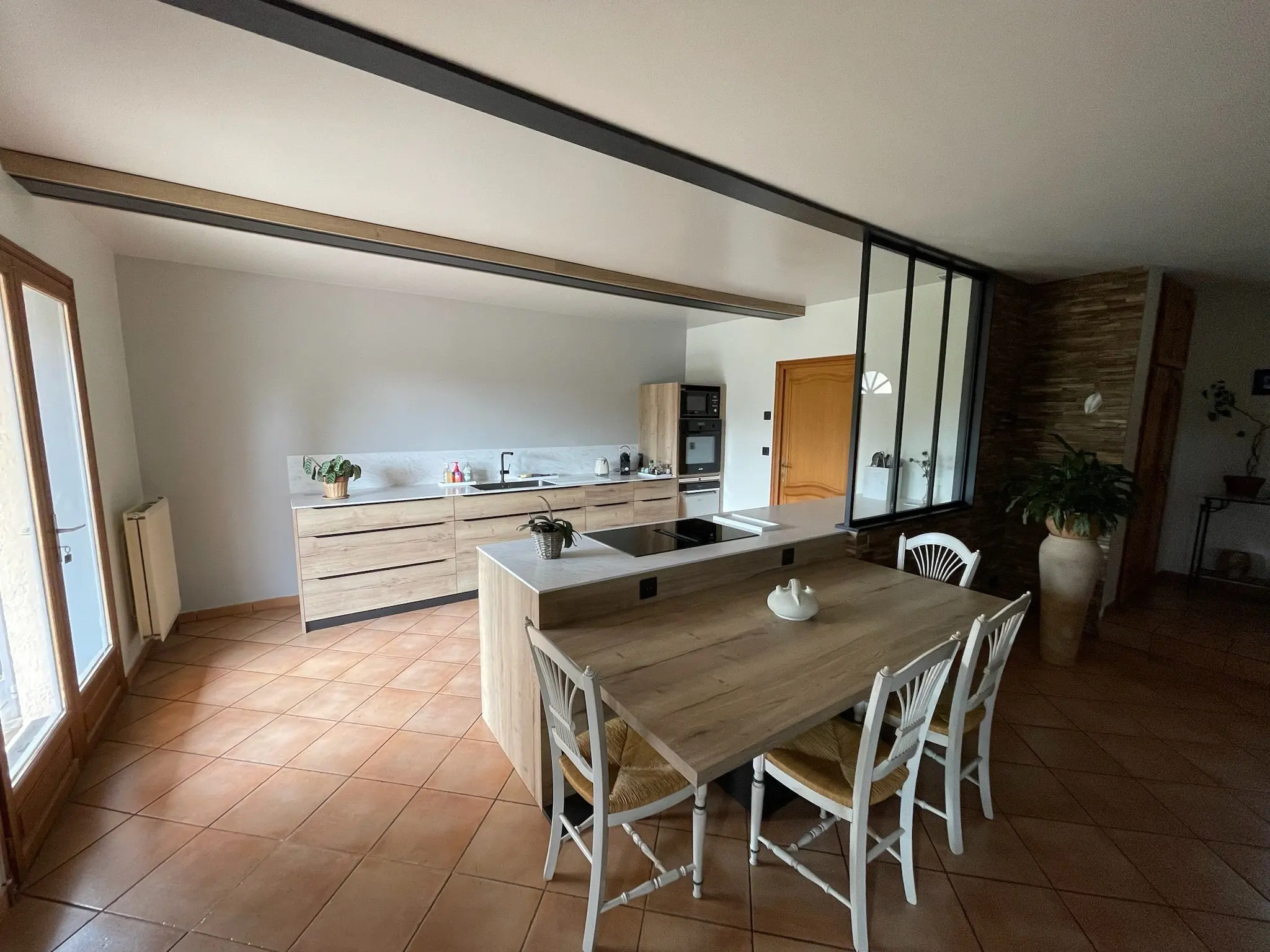 Cuisine sur mesure et îlot central vus depuis le séjour